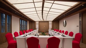 A conference room with a long table, red chairs, and a glass ceiling. - Wyndham Fengqing Resort (Lincang)