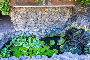 Stroll through a serene garden oasis, surrounded by lush greenery and a tranquil water feature.