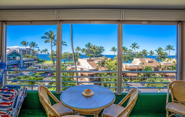 Enjoy a serene ocean view from this room's large window, featuring a seating area with a round table and single chair.