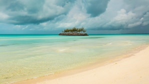 Een strand met helder turquoise water en een zandstrand.