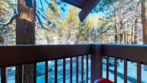 A wooden deck with a view of a snowy forest. - Horizons 4 186 Centrally Located, Spacious Mammoth Home with Cozy Fireplace by RedAwning (Mammoth Lakes)