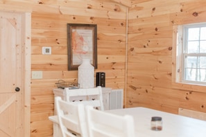 Relax in this inviting space with a comfortable chair, a stylish table, and a beautiful piece of artwork.