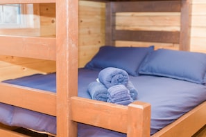 Cozy retreat with a comfortable bunk bed, featuring a blue mattress and matching pillows, and convenient storage for your essentials.