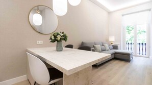 A modern living room with a dining area, a sofa, and a large window. - San Martin - The Rentals Collection (San Sebastián)