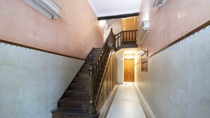 A staircase with a wooden handrail and a dark wooden floor leading to a landing. - San Martin - The Rentals Collection (San Sebastián)