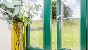 A window with a view of a grassy field and trees. - Pogles Wood Cottage (Skipton)