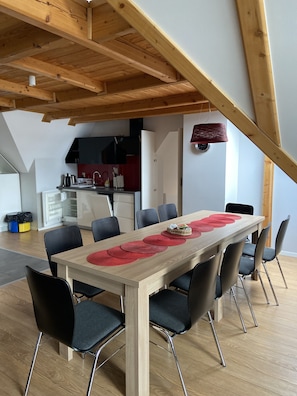 A dining area with a wooden table, black chairs, and red placemats. - Harenda Residence - Destigo Hotels (Zakopane)
