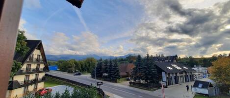 Una zona residencial con casas, una carretera y una cordillera al fondo.