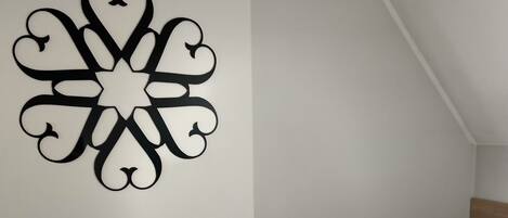 A neatly made bed with a patterned bedspread and a decorative wall piece.