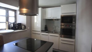 A compact kitchen with a built-in stove, a microwave, and a double oven. - Ground floor, parking, tv, ski locker, 61m², Valloire (Valloire)