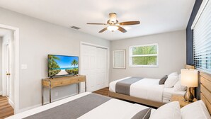 A bedroom with two beds, a desk, a ceiling fan, and a window with blinds. - Wonderful 4BR & 3BA Villa Heated Pool near Beach (Hollywood)
