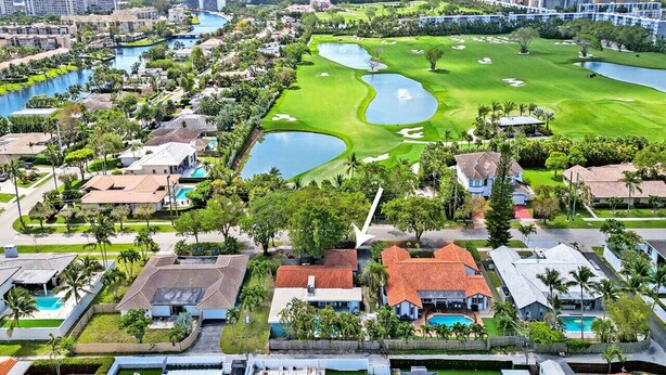 A golf course with multiple ponds, surrounded by residential buildings and a city skyline in the background. - Wonderful 4BR & 3BA Villa Heated Pool near Beach (Hollywood)
