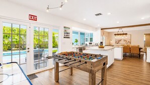 A modern kitchen with a foosball table, a dining area, and a pool view. - Wonderful 4BR & 3BA Villa Heated Pool near Beach (Hollywood)