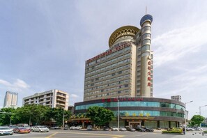 A hotel with a prominent tower, multiple floors, and a curved facade. - Golden Diamond Hotel (Zhaoqing)
