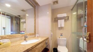 Un baño con lavamanos, espejo, inodoro y ducha.
