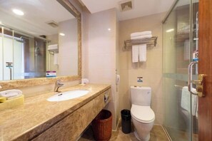 Ein Badezimmer mit Waschbecken, Spiegel, Toilette und Dusche.