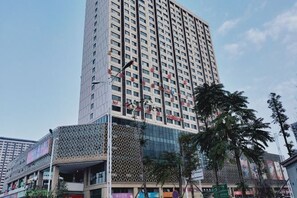 Un edificio alto con varios pisos, fachada de vidrio y revestimiento con diseño.