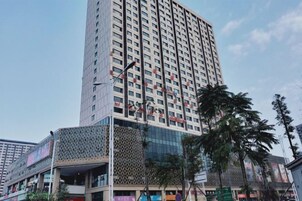 Un edificio alto con varios pisos, fachada de vidrio y revestimiento con diseño.