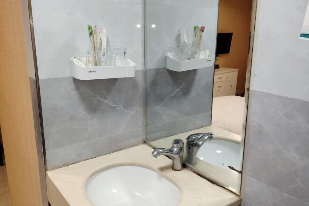 Un bany amb un lavabo, mirall i suport per esbocinadors.