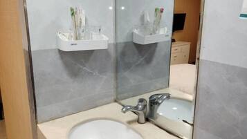 Un bany amb un lavabo, mirall i suport per esbocinadors.