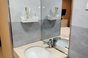 A bathroom with a sink, mirror, and toothbrush holder. - Guang'an Yandu Hotel (Guang'an)