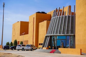 A modern building with a unique architectural design, featuring a prominent staircase and a glass entrance. - Hotel Al Salam Resort (Nouakchott)