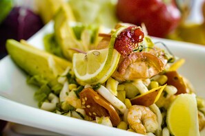 A plate of seafood salad with shrimp, corn, and lime slices. - Hotel Al Salam Resort (Nouakchott)