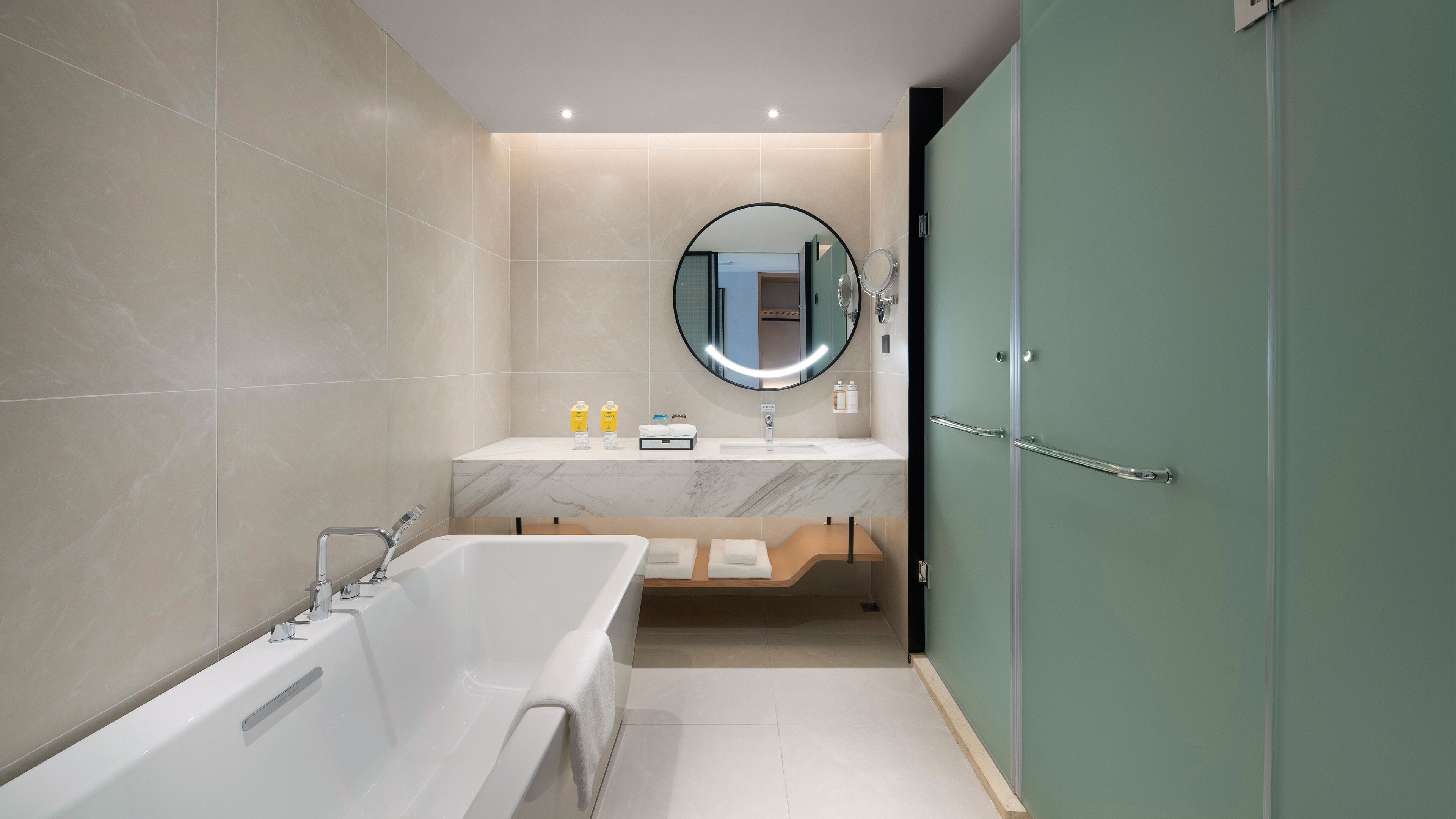 A modern bathroom with a bathtub, a sink with a mirror, and a shower area.