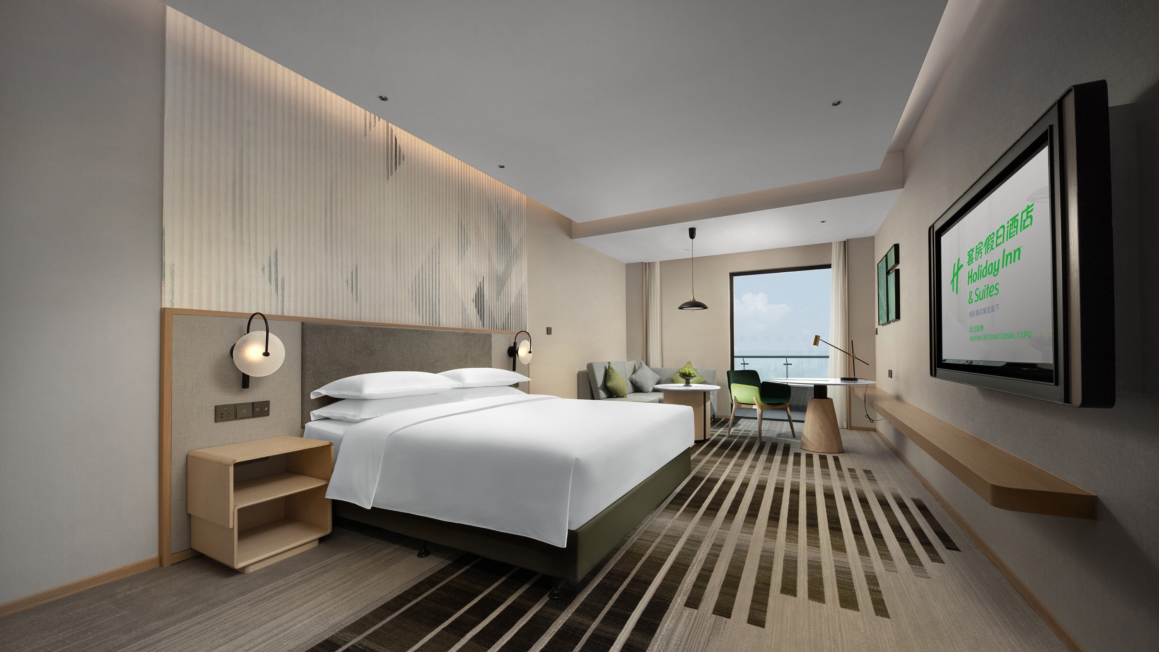 A modern hotel room with a large bed, bedside tables, a desk, and a view of the city.