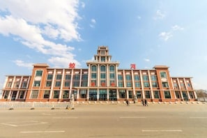 A large, multi-story building with a prominent central tower and large windows.