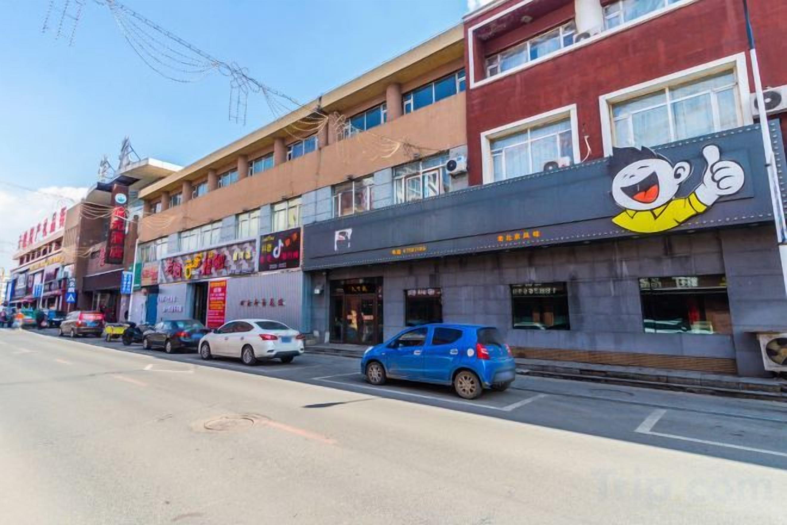 Una calle con varios comercios, incluyendo un restaurante con logotipo de personaje de dibujos animados.