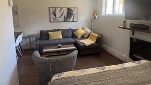 A living room with a sofa, a coffee table, a lamp, a TV, and a fireplace.