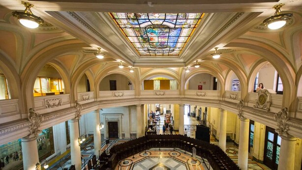 A grand hall with a central staircase, ornate columns, and a large stained glass ceiling. - Santos Linda !! 5 min from the beach ! (SP)