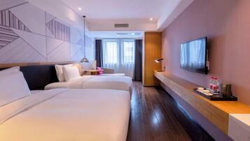Habitación de hotel con dos camas, televisión, escritorio con lámpara y ventana grande.