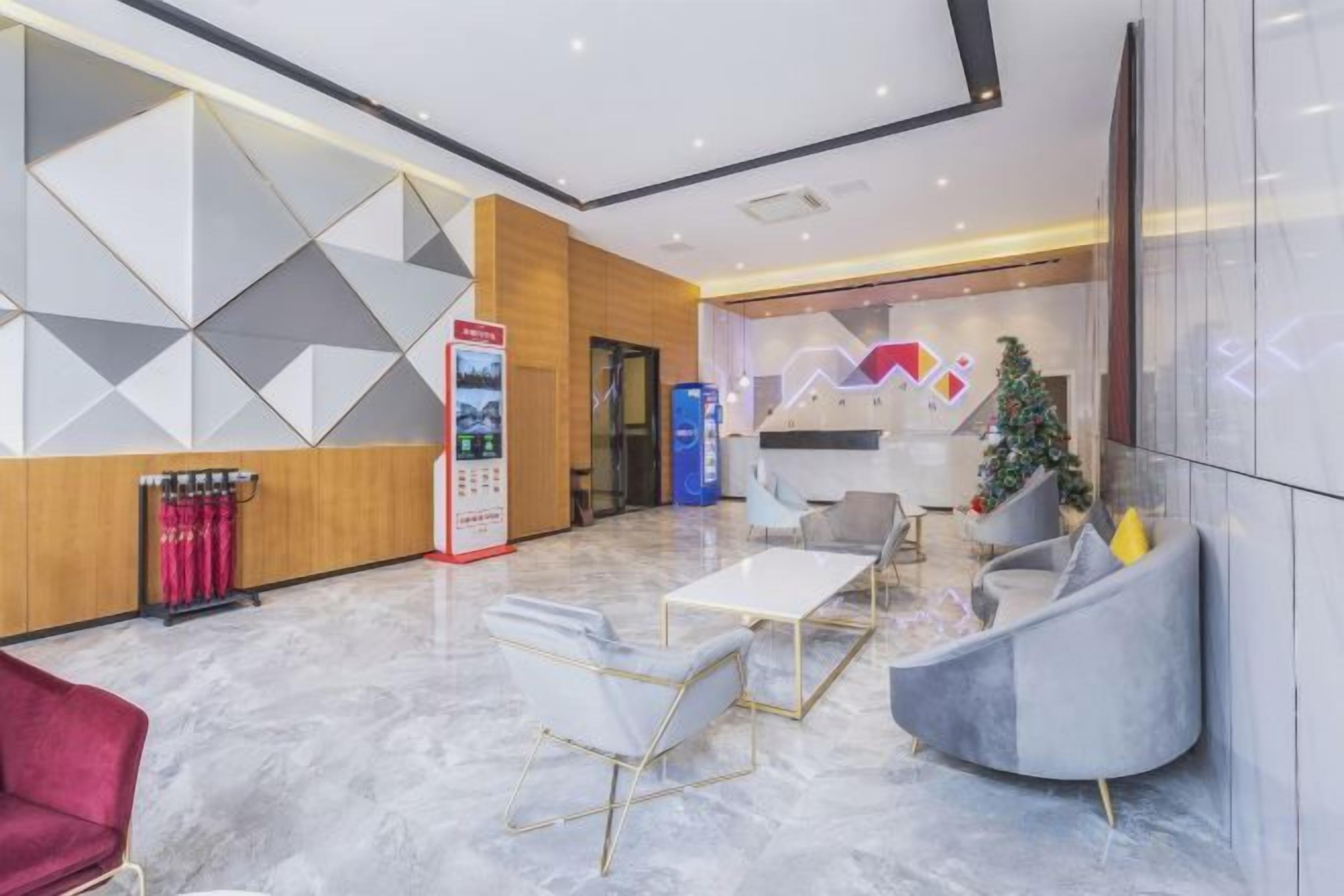 Un hall d’entrée moderne avec un comptoir d’accueil, un espace salon et un sapin de Noël.
