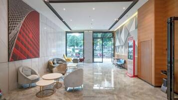 A modern lobby with seating, a reception desk, and a glass door leading outside.