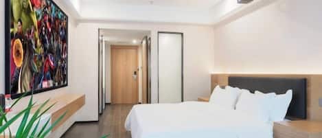 A modern hotel room with a large bed, a bedside table, a nightstand, a large artwork on the wall, and a door leading to another room.