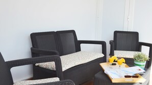 A corner of a room with wicker furniture, a tray with drinks and a map, and a potted plant. - House Maresía Las Moreras Duplex with Sea View 1 minute from the seafront promenade  (Playa Blanca)