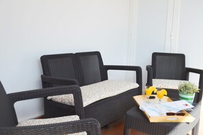 A corner of a room with wicker furniture, a tray with drinks and a map, and a potted plant. - House Maresía Las Moreras Duplex with Sea View 1 minute from the seafront promenade (Playa Blanca)