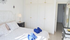 A bedroom with a bed, a nightstand, a wardrobe, and a desk with a lamp. - House Maresía Las Moreras Duplex with Sea View 1 minute from the seafront promenade  (Playa Blanca)