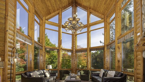A log cabin interior with a high ceiling, large windows, and a chandelier. - Lakefront secluded mult-family retreat with game room and two cabins.  (Townsend)