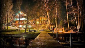A wooden cabin with a porch, a dock, and a small bridge over a body of water. - Lakefront secluded mult-family retreat with game room and two cabins.  (Townsend)