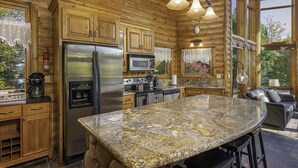 A log cabin kitchen with granite countertops, stainless steel appliances, and a large island. - Lakefront secluded mult-family retreat with game room and two cabins.  (Townsend)