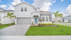 A modern two-story house with a garage, a front porch, and a well-maintained lawn. - Star Wars Themed Game Room • Private Pool • Lazy River • Resort • Near Disney (Davenport)