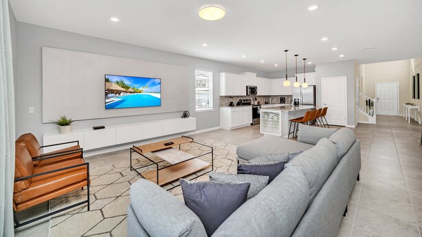 A modern living room with a sofa, coffee table, and a TV mounted on the wall. - Star Wars Themed Game Room • Private Pool • Lazy River • Resort • Near Disney (Davenport)