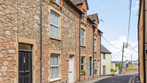 A row of stone buildings with a narrow street. - Sea Spray (Watchet)