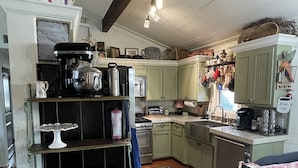 A kitchen with wooden cabinets, a stove, and various kitchen appliances.