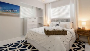 A bedroom with a bed, a nightstand, a dresser, and a painting on the wall. - Walk to Fort Lauderdale Beach - Perfect Beach Escape (Fort Lauderdale)