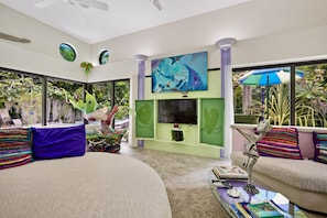 Relax in this stylish living room with a large TV, comfortable sofas, and a beautiful view.