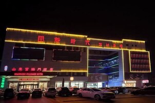 A hotel with illuminated signage and a parking lot.